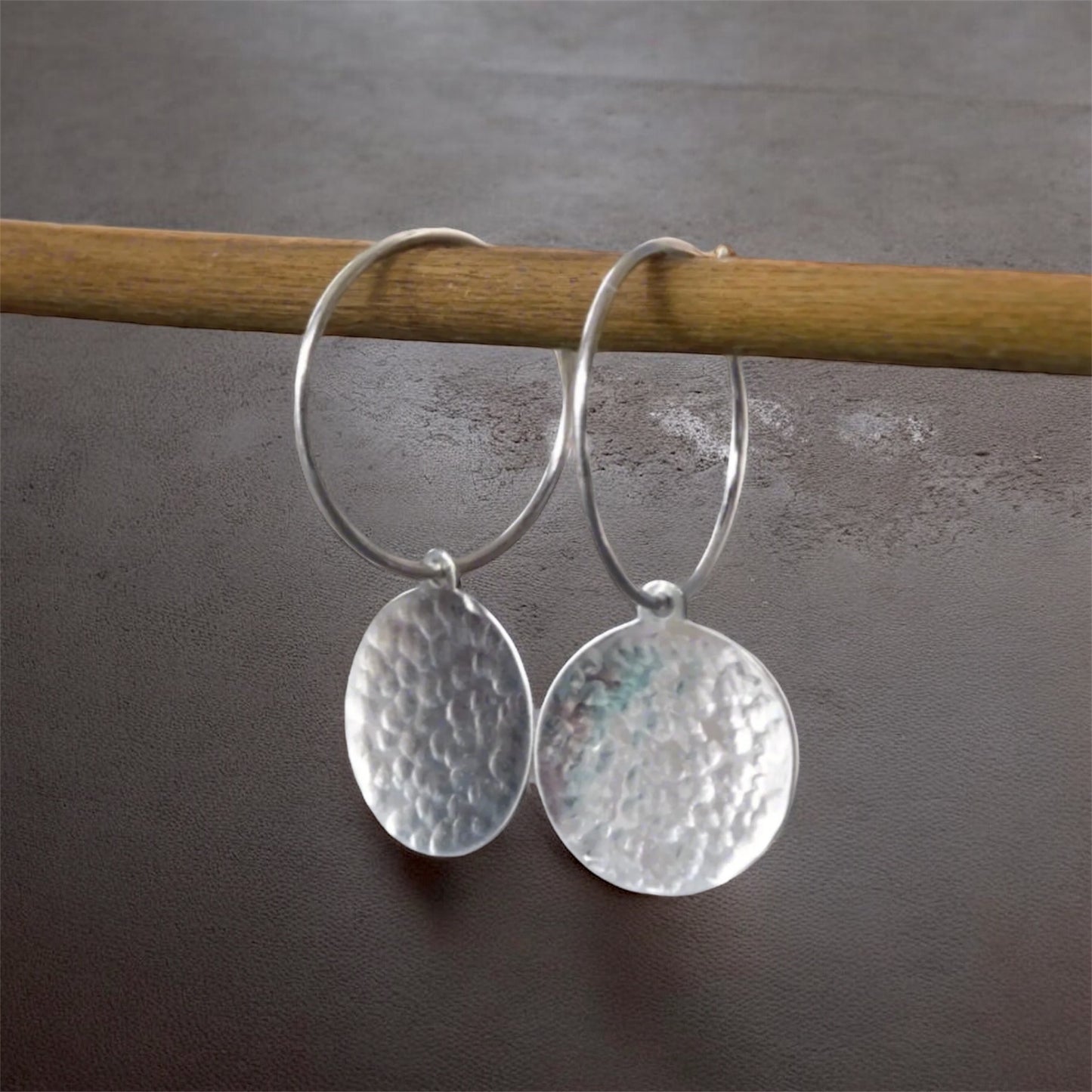 Hammered sterling silver disc hoop earrings.