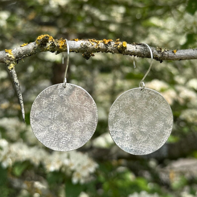 Large silver hammered disc dangle earrings.
