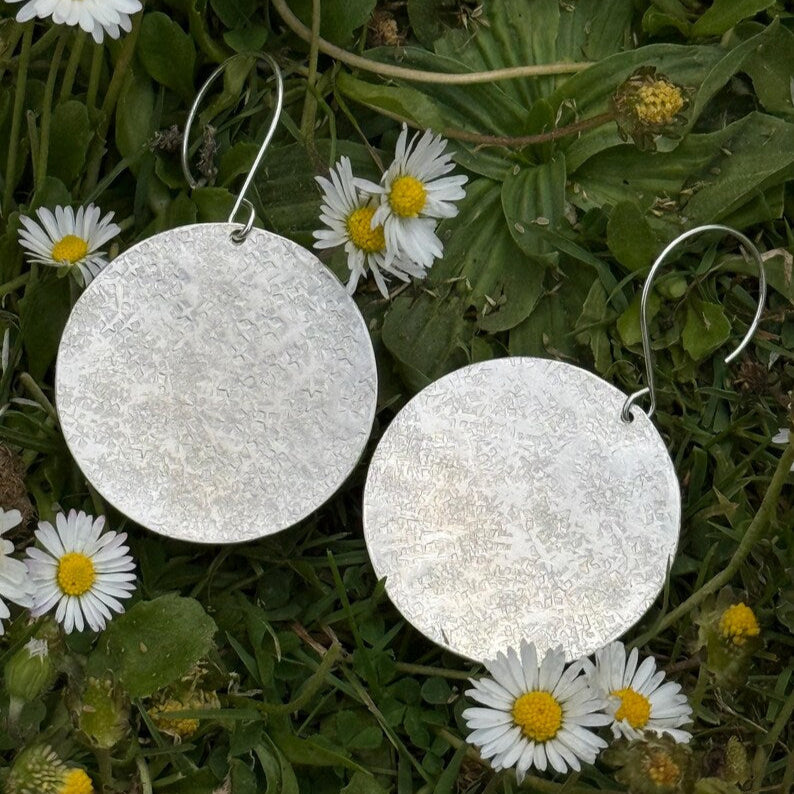Large silver hammered disc dangle earrings.