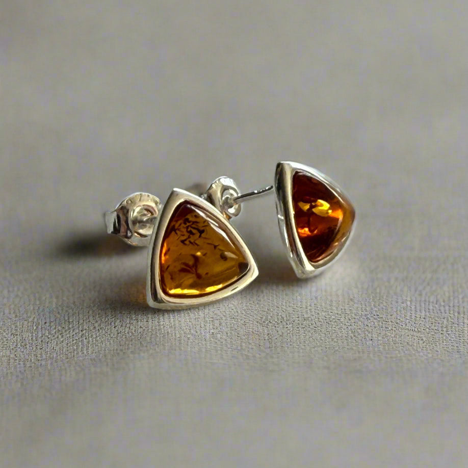 Sterling silver stud earring with amber stones on a light linen background