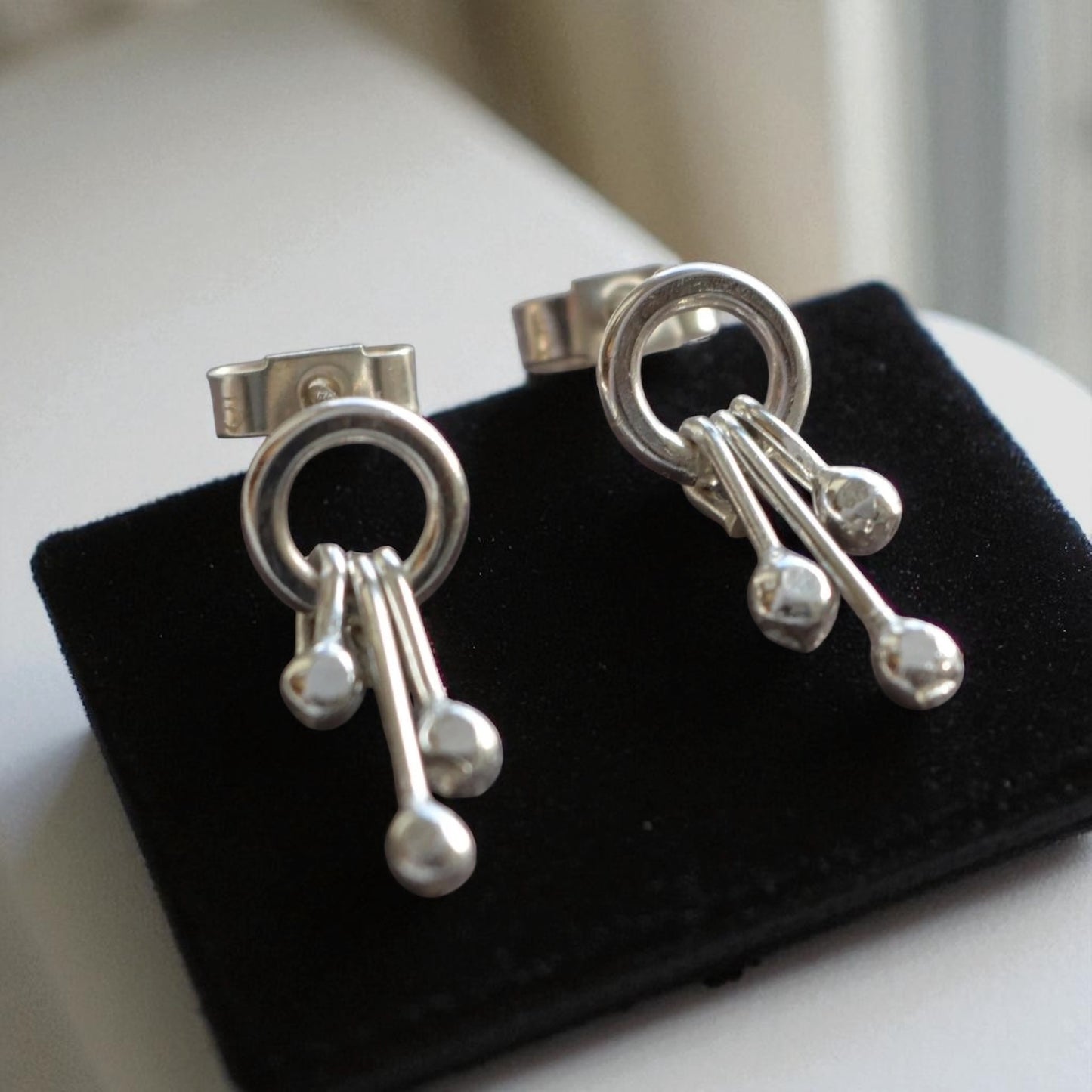 Sterling silver circle and droplets stud earrings.