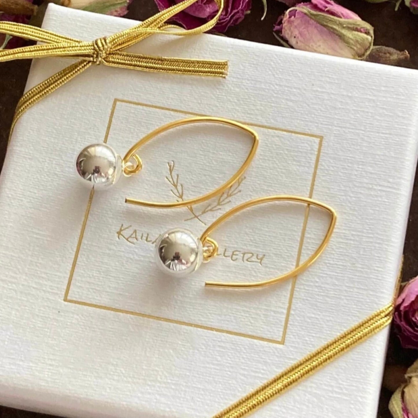 Silver and gold ball dangle earrings.