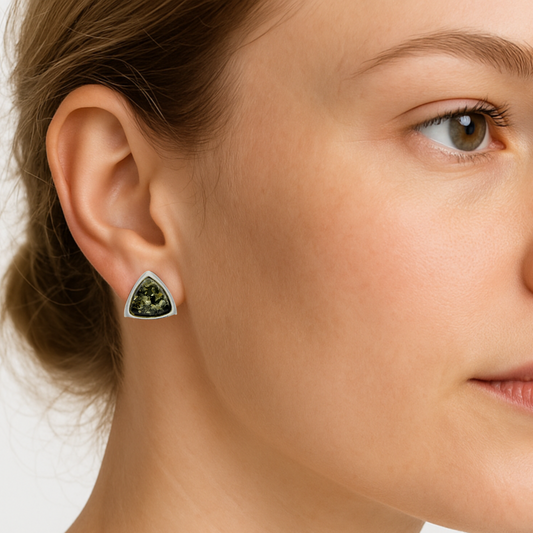 Close-up of a woman wearing a green amber and sterling silver earring.