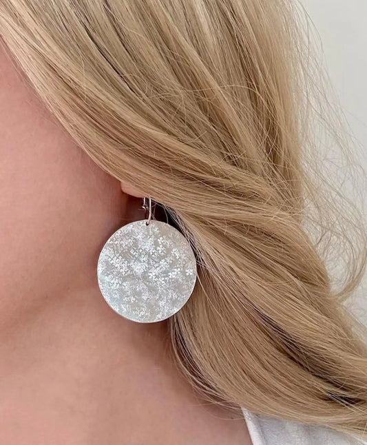 Large sterling silver textured disc hoop earrings.