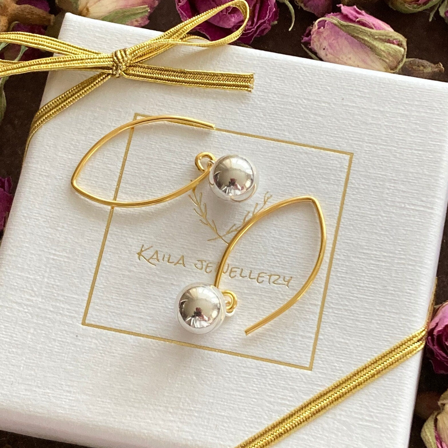Silver and gold ball dangle earrings.