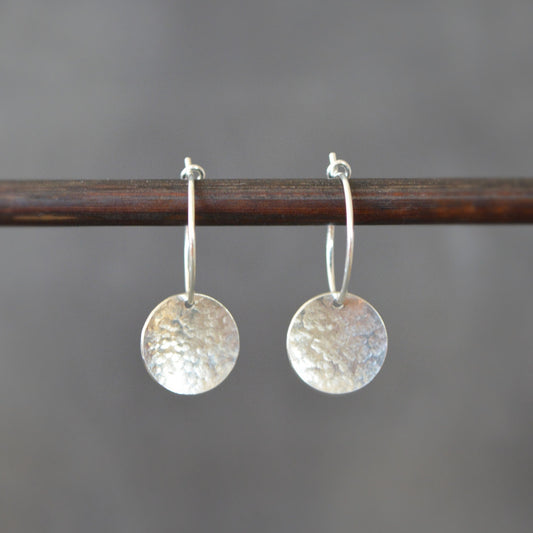 Sterling silver hammered disc hoop earrings.