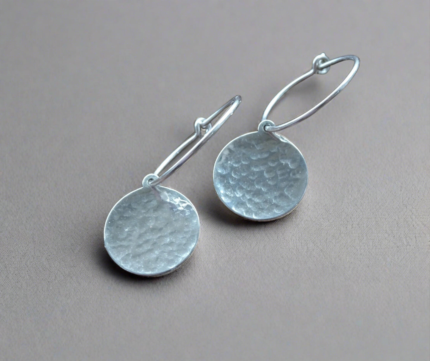 Hammered sterling silver disc hoop earrings.