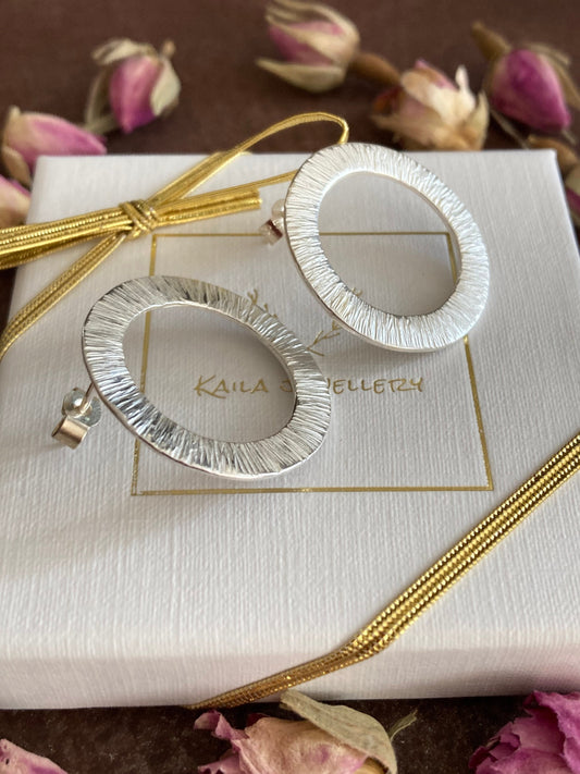 Large sterling silver circle stud earrings.