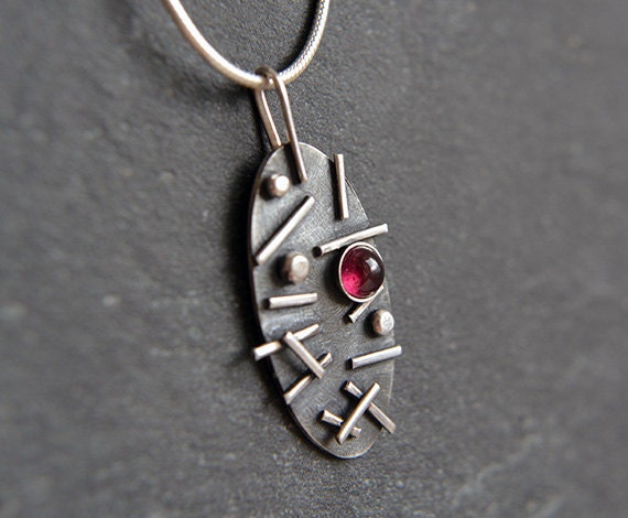 Garnet oxidised sterling silver oval necklace.