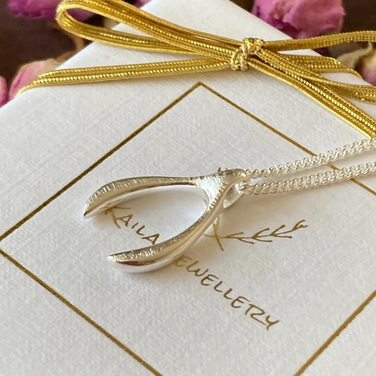 Sterling silver wishbone necklace with a hand-hammered, textured finish on a polished silver curb chain. The elegant wishbone pendant symbolises luck, hope and positivity, making it a meaningful gift or stylish everyday accessory.