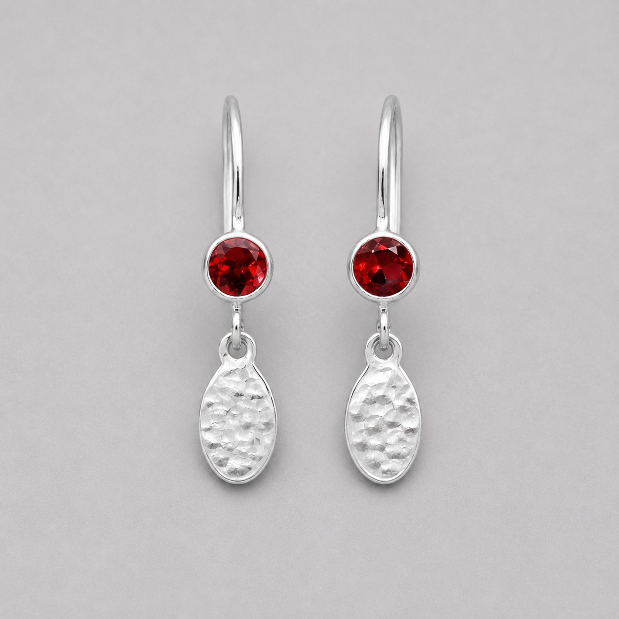 Garnet birthstone sterling silver dangle textured oval earrings.