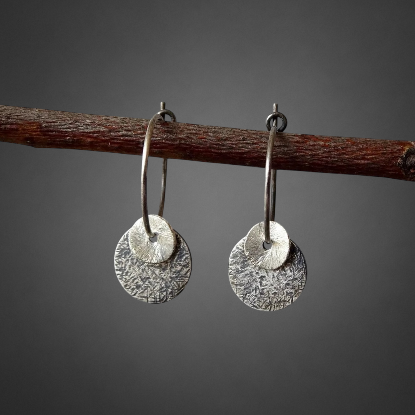 Sterling silver oxidised hammered disc hoop earrings.