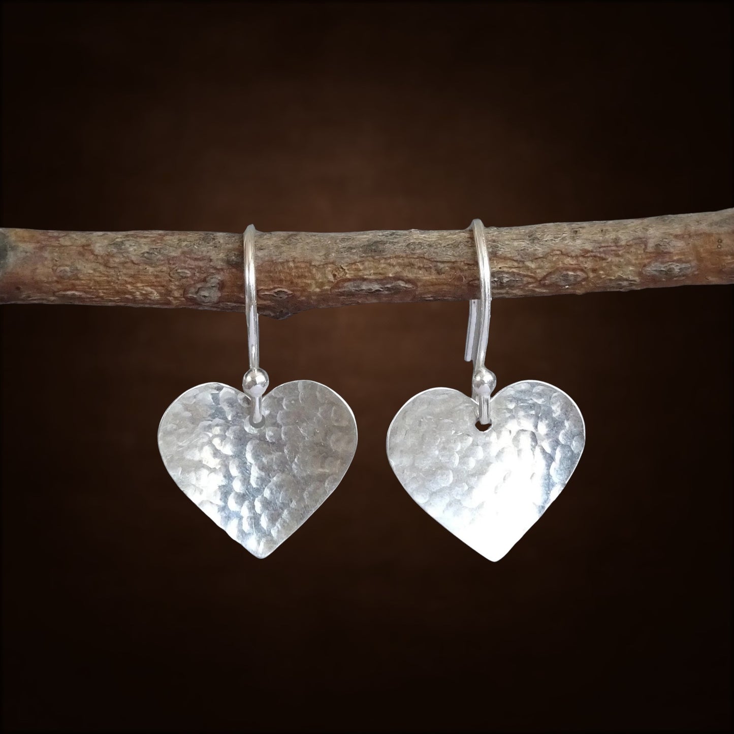 Sterling silver hammered heart dangle earrings.