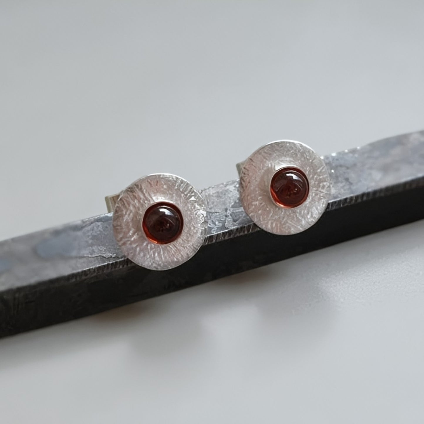 Garnet sterling silver disc stud earrings.