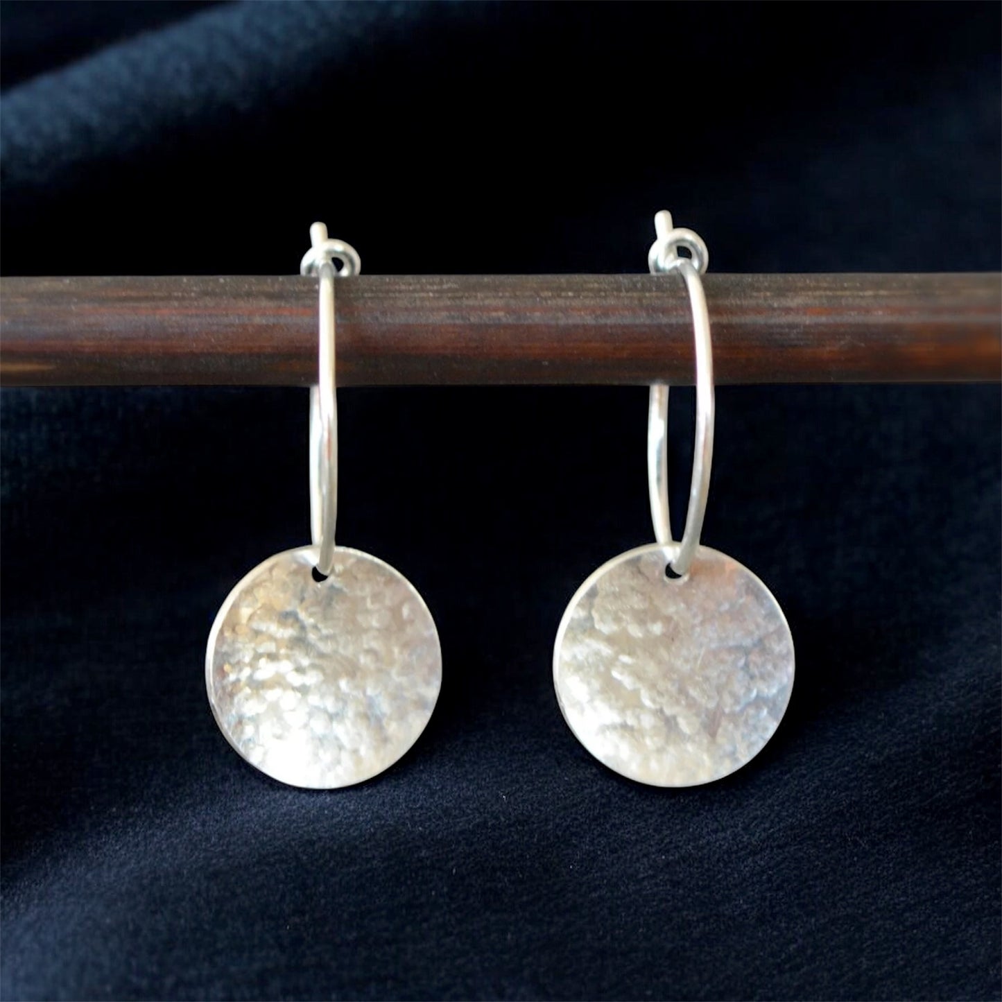 Sterling silver hammered disc hoop earrings.