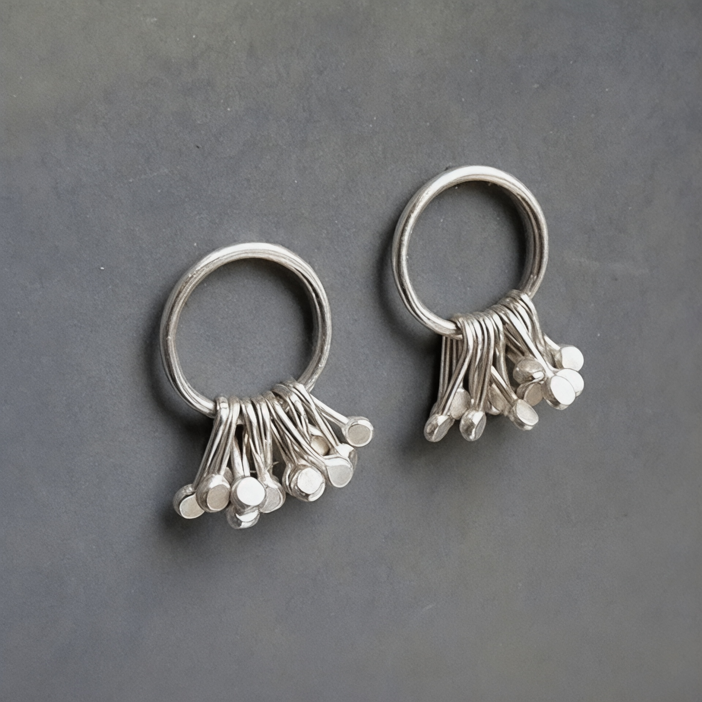 Sterling silver circle and droplets stud earrings.