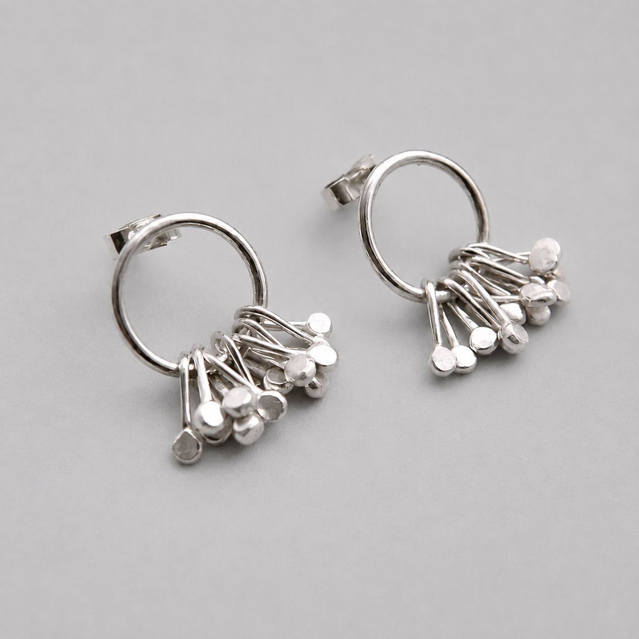 Sterling silver circle and droplets stud earrings.
