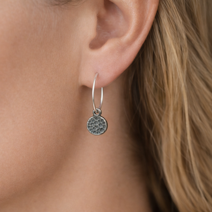 Hammered sterling silver disc charm hoop earrings.