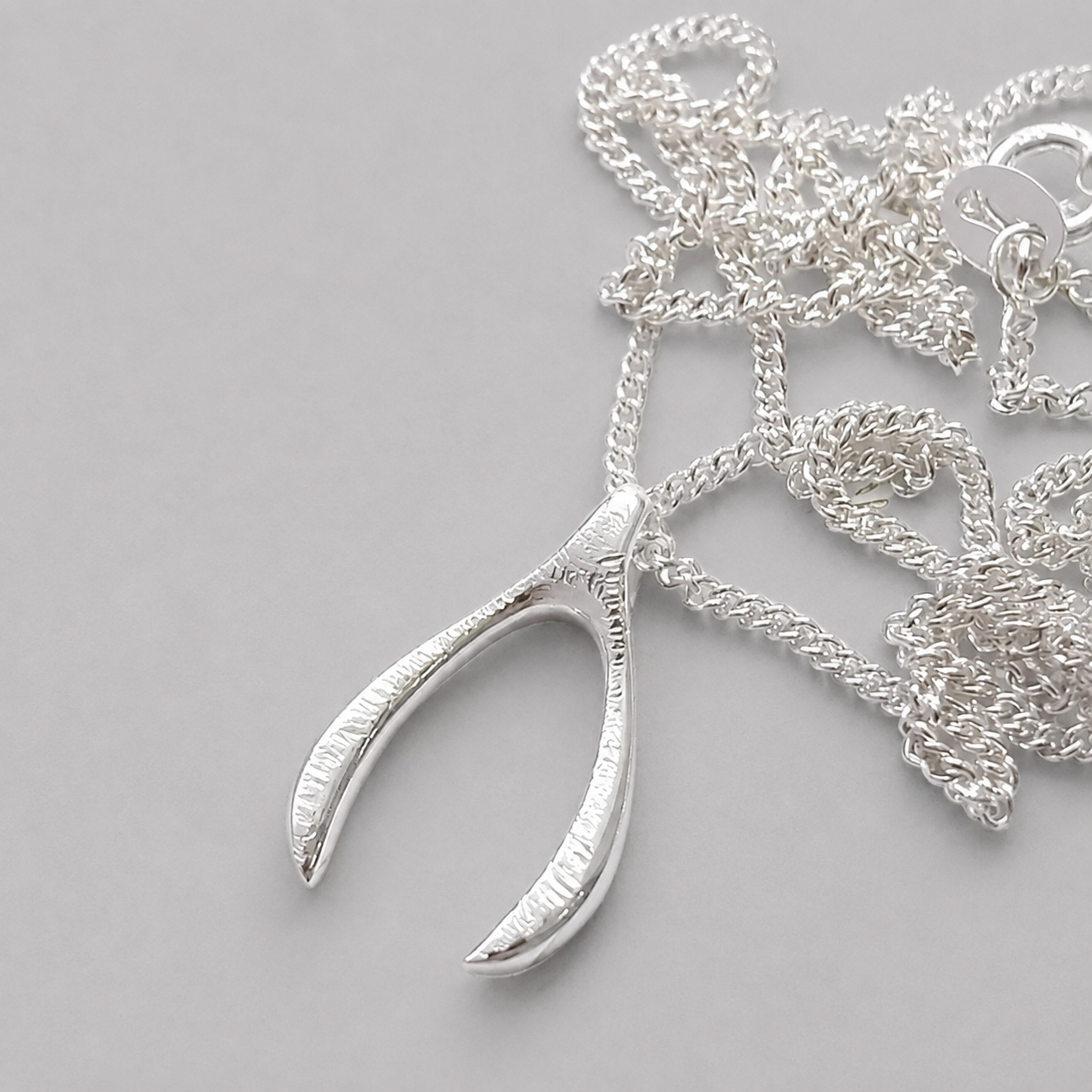 Sterling silver textured wishbone necklace.