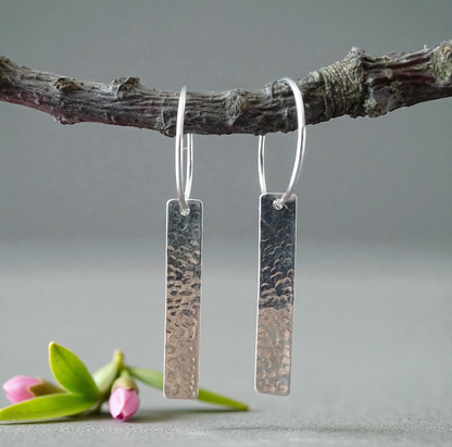 Sterling silver dangle hammered oblong hoop earrings.