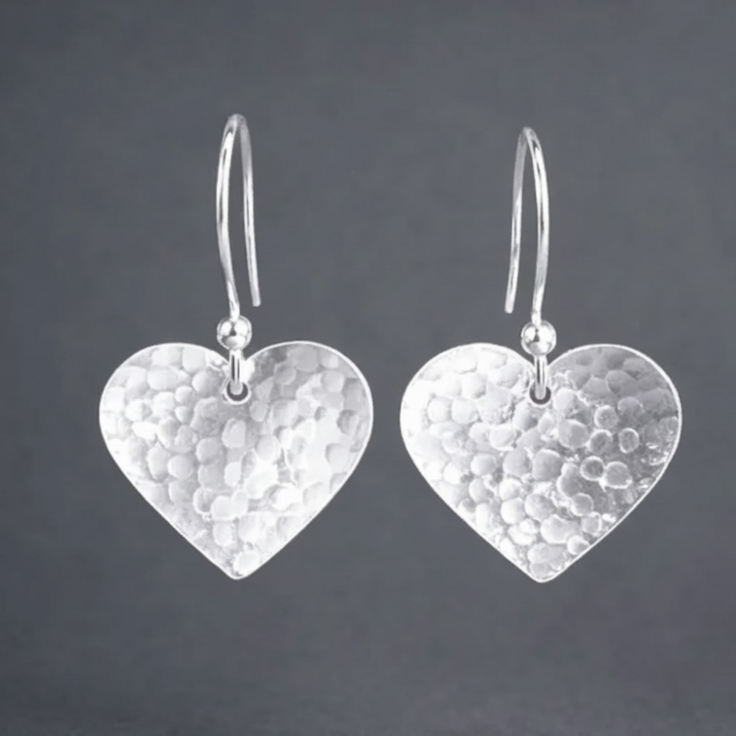 Sterling silver hammered heart dangle earrings.