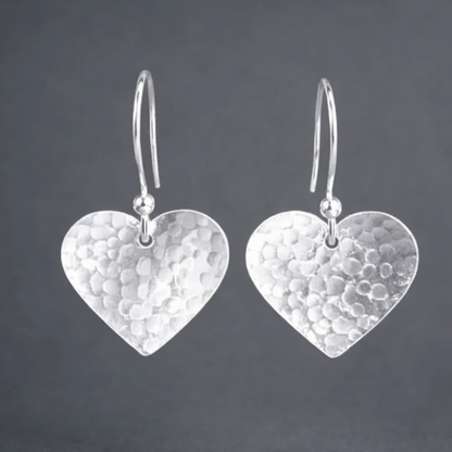 Sterling silver hammered heart dangle earrings.