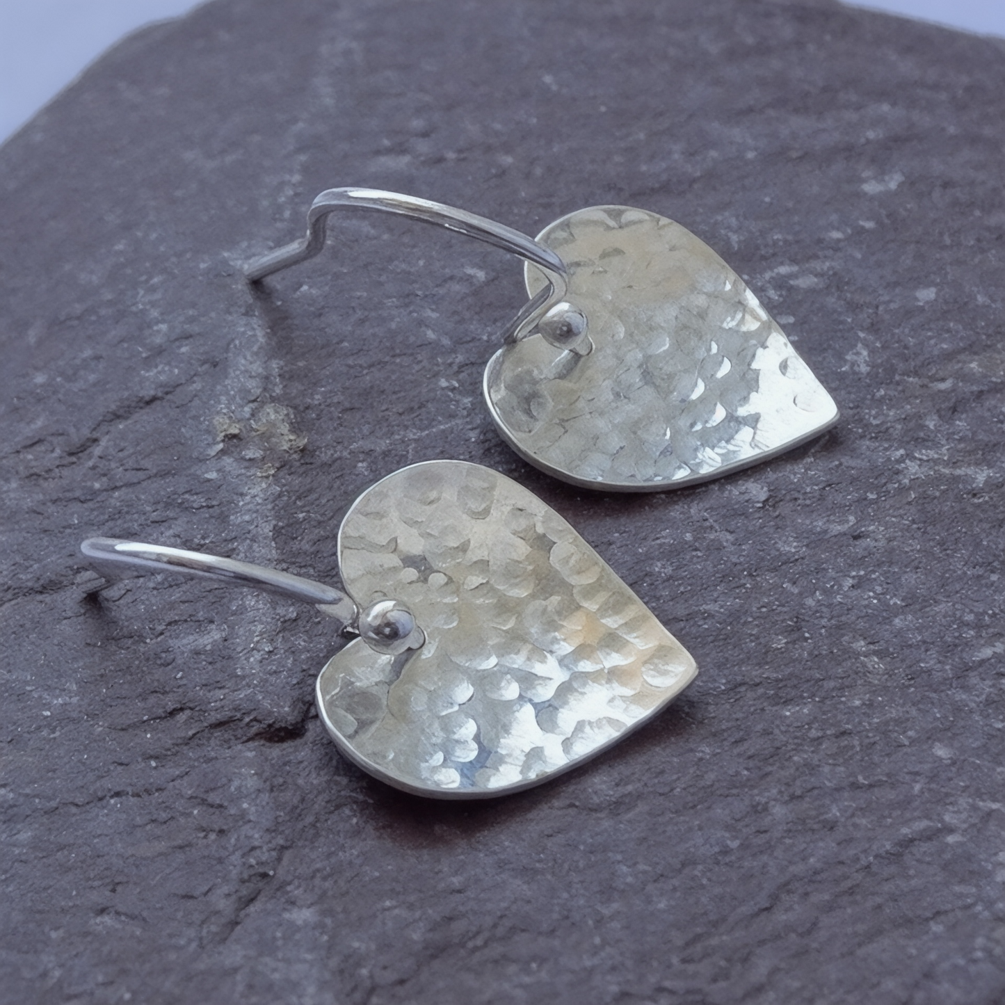Sterling silver hammered heart dangle earrings.