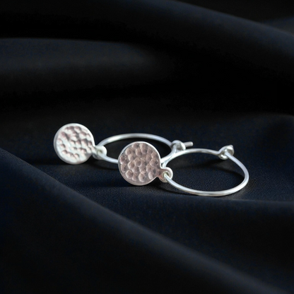 Small hammered sterling silver disc charm hoop earrings.