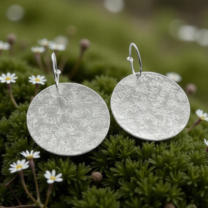 Large sterling silver textured disc hoop earrings.