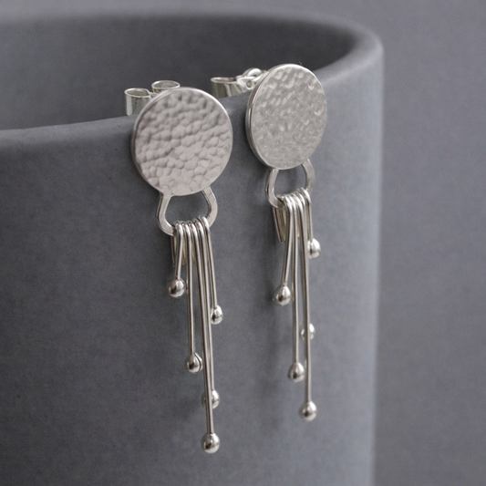 Sterling silver dangle textured disc earrings.