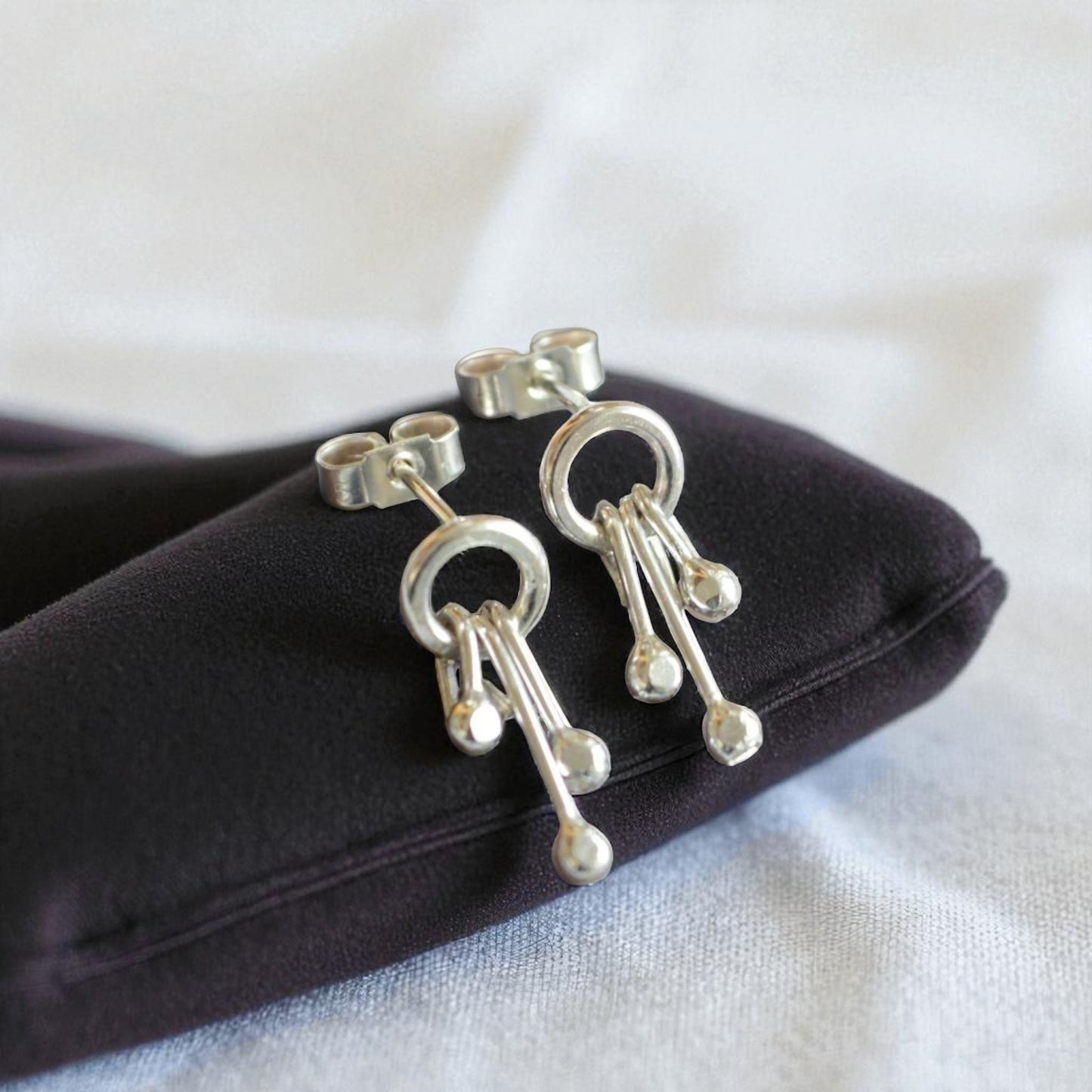 Sterling silver circle and droplets stud earrings.