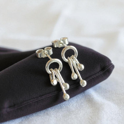 Sterling silver circle and droplets stud earrings.