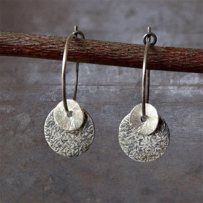 Sterling silver oxidised hammered disc hoop earrings.
