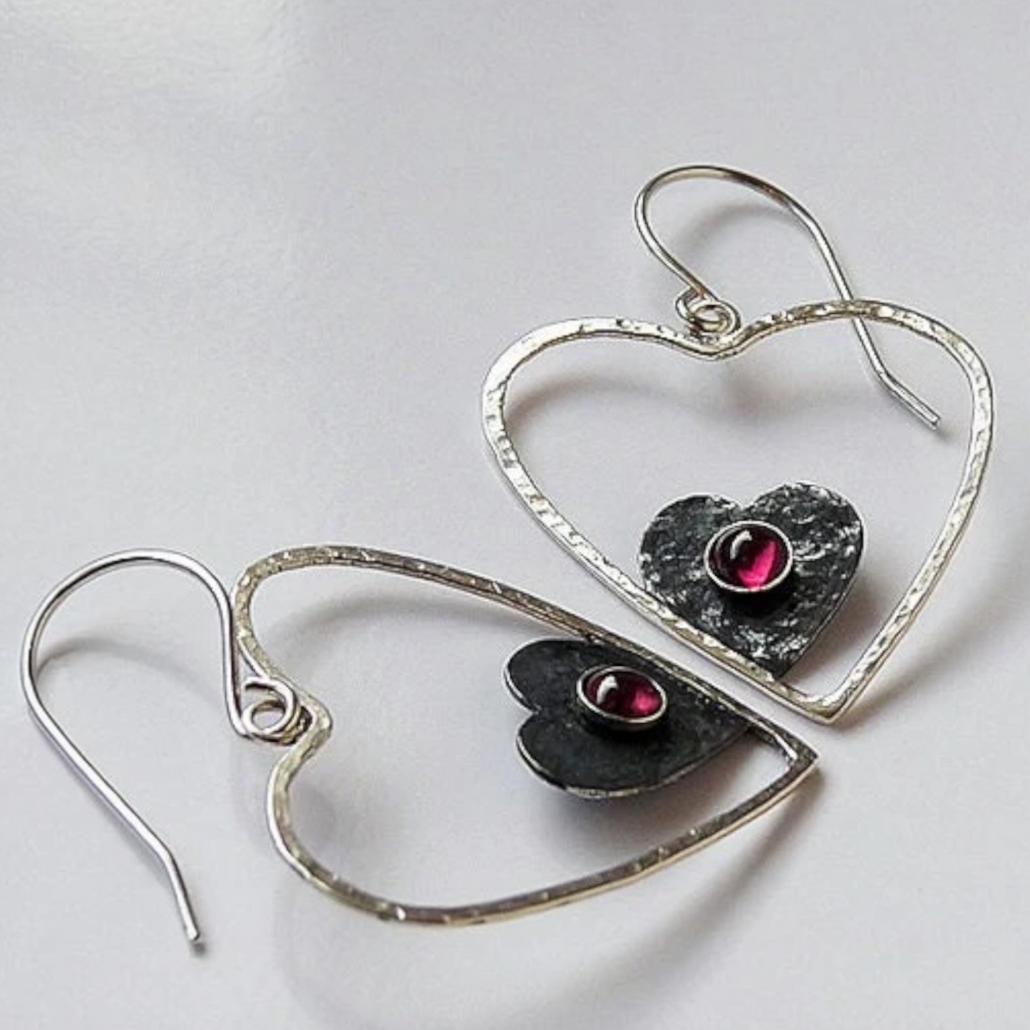 Sterling silver garnet heart earrings.