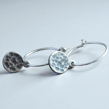 Hammered sterling silver disc charm hoop earrings.