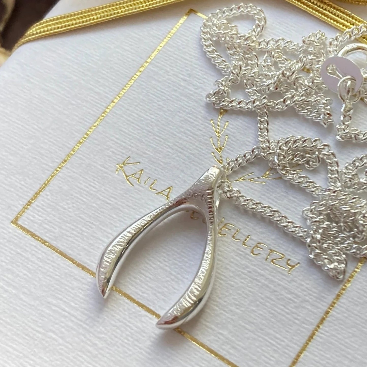 Sterling silver textured wishbone necklace.