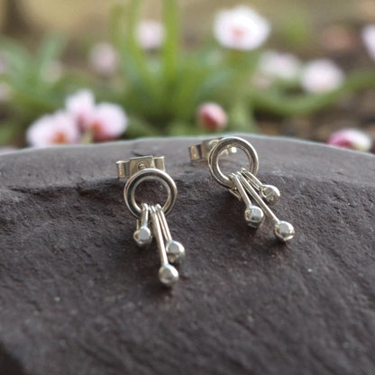 Sterling silver circle and droplets stud earrings.