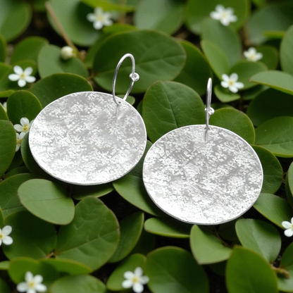 Large sterling silver textured disc hoop earrings.