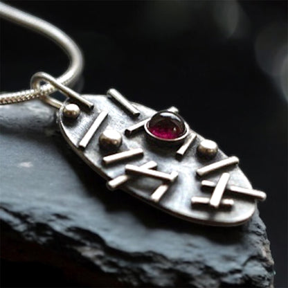 Garnet oxidised sterling silver oval necklace.