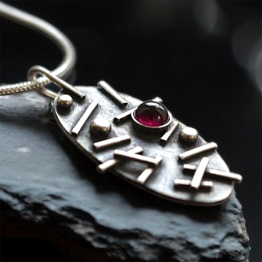 Garnet oxidised sterling silver oval necklace.