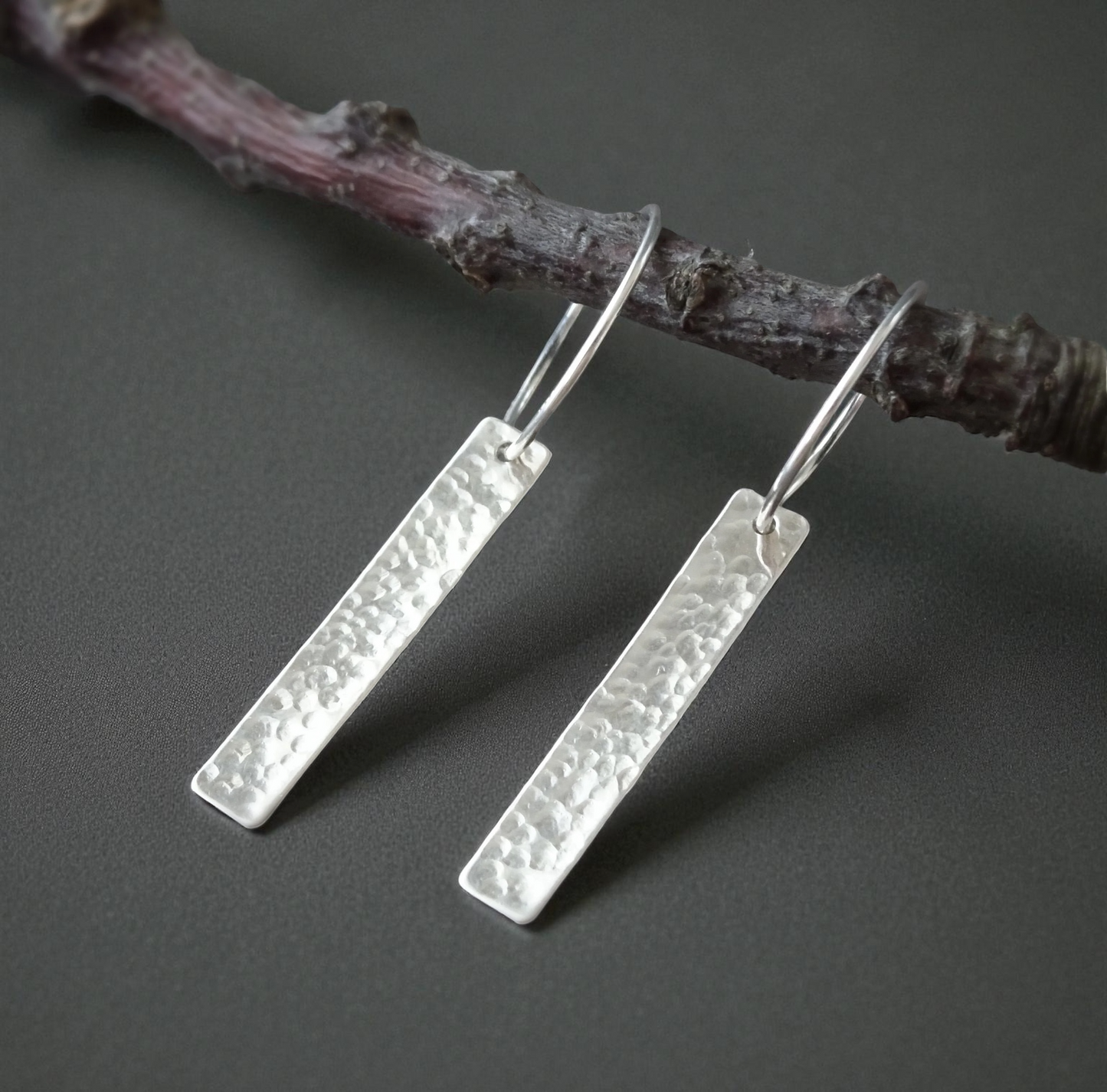 Sterling silver dangle hammered oblong hoop earrings.