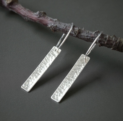 Sterling silver dangle hammered oblong hoop earrings.