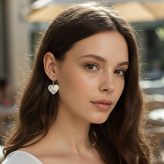 Sterling silver hammered heart dangle earrings.