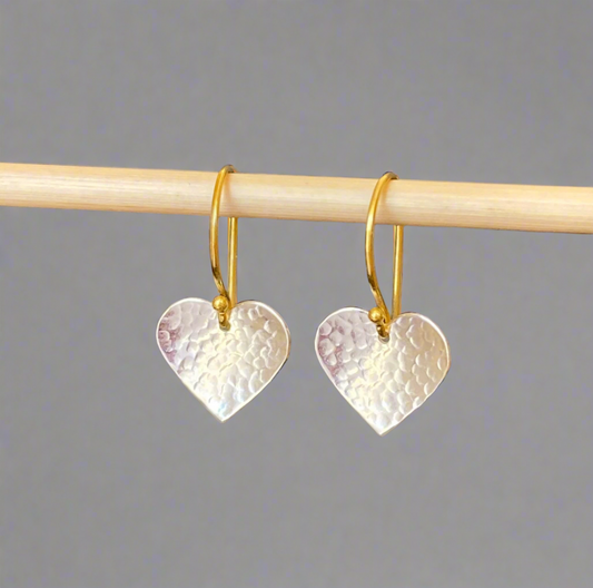 Silver and gold textured heart dangle earrings.