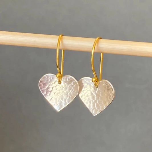Silver and gold textured heart dangle earrings.