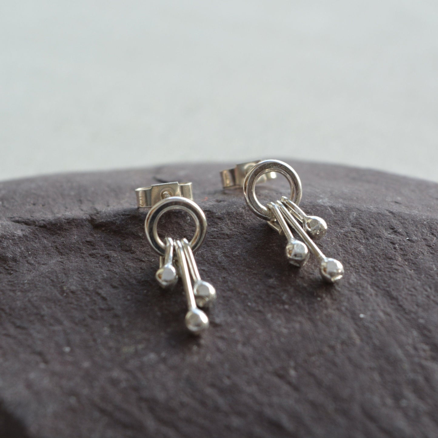 Sterling silver circle and droplets stud earrings.