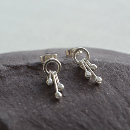 Sterling silver circle and droplets stud earrings.