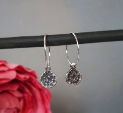 Small hammered sterling silver disc charm hoop earrings.