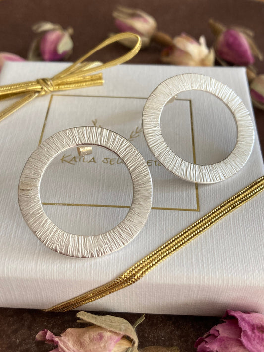 Large sterling silver circle stud earrings.