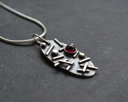 Garnet oxidised sterling silver oval necklace.